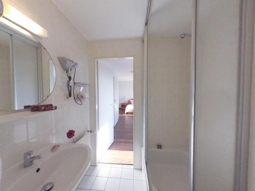 ein Badezimmer mit einer Badewanne, einem Waschbecken und einem Spiegel in der Unterkunft Hotel Kaiser in Mönchengladbach
