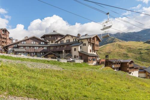 a group of buildings on a hill with a chair lift at Résidence l'Oxalys in Val Thorens