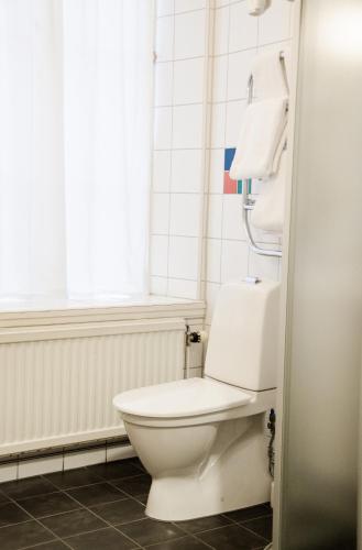 a white toilet in a bathroom with a window at Hotel Vanilla in Gothenburg