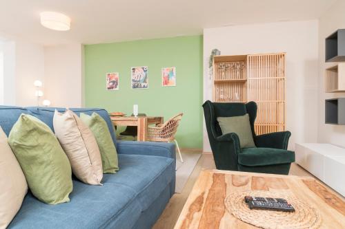 a living room with a blue couch and a chair at Stephansdom Premium Apartments in Vienna