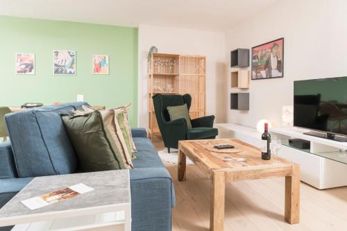 a living room with a blue couch and a table at Stephansdom Premium Apartments in Vienna