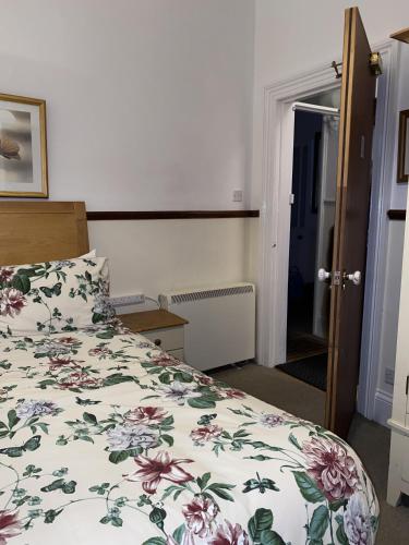 a bedroom with a bed with a floral bedspread at Seaford Lodge Apartments in Weston-super-Mare