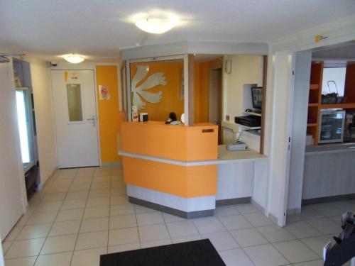 a kitchen with an orange counter in a room at Première Classe Metz Nord - Talange in Talange