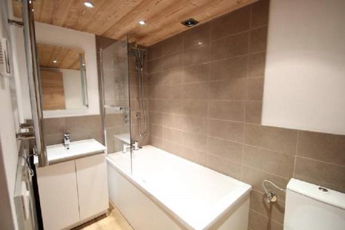 a bathroom with a bath tub and a sink at Just Morzine - Apartment Luna in Morzine