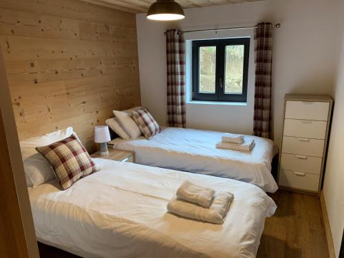 a bedroom with two beds and a window at Just Morzine - Apartment Luna in Morzine