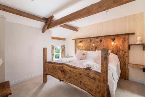 a bedroom with a wooden bed with white sheets at Orchard House in Rosedale Abbey