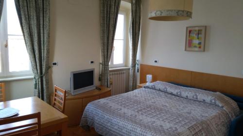 a bedroom with a bed and a desk and a tv at Residence Al Granzo in Trieste
