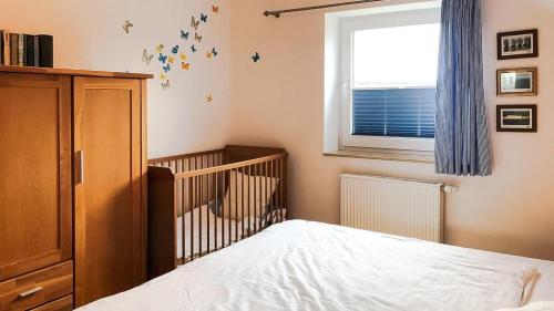 a bedroom with a crib and a window at Haus Alte Bäckerei - Boddenblick in Born