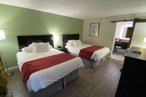 a hotel room with two beds and a bathroom at Lx Hotel, Manchester, Tennessee in Manchester