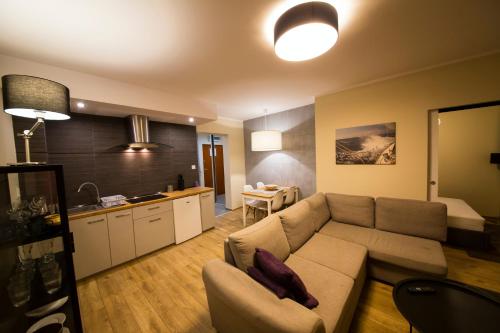 a living room with a couch and a kitchen at Wyspa Uznam - Apartamenty Zdrojowa in Świnoujście