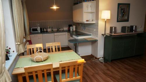 a small kitchen with a table and a dining room at Haus "Zur Seebrücke" - Deichblick in Zingst