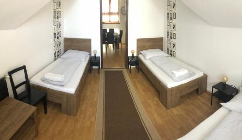 two beds in a room with wooden floors at Petra Vendégház in Szekszárd