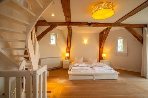 ein Schlafzimmer mit einem Bett in einem Zimmer mit Holzdecken in der Unterkunft Darßer Mühle in Born