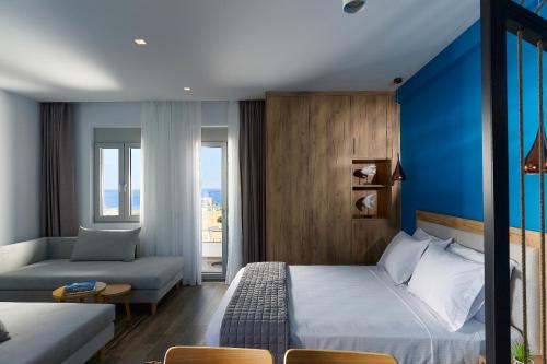 pokój hotelowy z łóżkiem i kanapą w obiekcie Theasea Stylish Residences w mieście Panormos