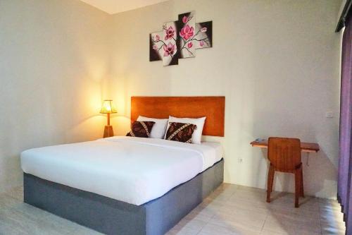 a bedroom with a large bed and a table at sammy cottage senggigi in Mangsit