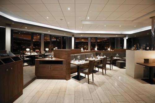 SteinfeldにあるBergmark Hotelのレストラン内のテーブルと椅子のあるダイニングルーム