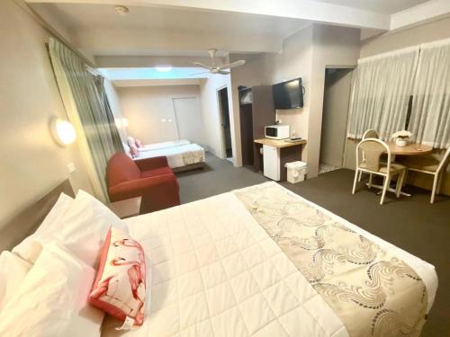 a hotel room with a bed and a living room at Apollo Motel Parkes in Parkes