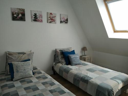 deux lits côte à côte dans une pièce dans l'établissement Villa proche plages, à Fouesnant