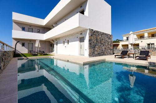 a swimming pool in a villa with a house at Theasea Stylish Residences in Panormos Rethymno