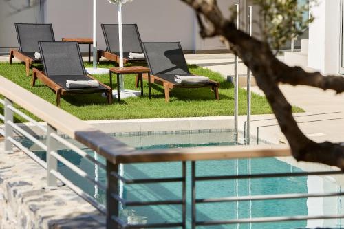 een rij stoelen naast een zwembad bij Theasea Stylish Residences in Panormos Rethymno