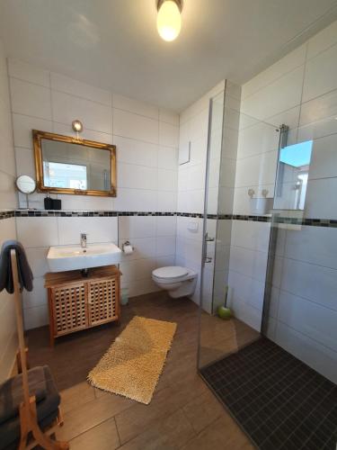 uma casa de banho com um lavatório e um WC em Villa-Panter em Sassnitz