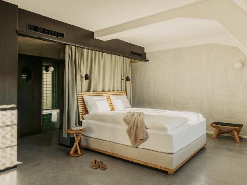 - une chambre avec un grand lit blanc dans l'établissement Boutique & Design Hotel Volkshaus Basel, à Bâle