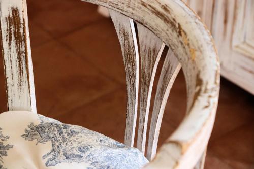 an old chair with chipping paint on it at Case di Berto in Capo Vaticano