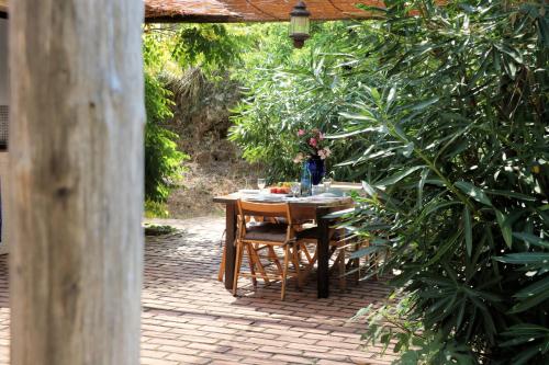 a table and chairs sitting under a wooden pergola at Case di Berto in Capo Vaticano