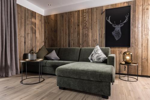a living room with a green couch and a chair at Seven Reasons / Panorama View in Hart im Zillertal