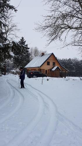 a person on skis in the snow in front of a house at Dom w krainie Bugu in Korczew