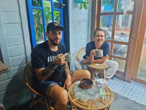 a man and woman sitting at a table drinking coffee at KALINDA HOMEY in Karimunjawa