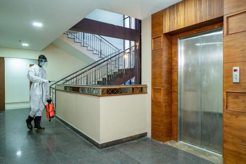 a person standing in a hallway with a staircase at Nexstay Treats Inn in Kozhikode