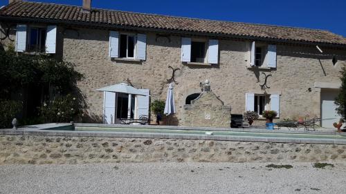a house with a swimming pool in front of it at Chambres d'hôtes Le Vignoble in Cucuron