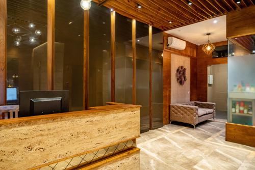 a lobby with a television and a chair at Nexstay Treats Inn in Kozhikode
