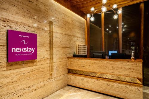 a lobby of a restaurant with a purple sign on the wall at Nexstay Treats Inn in Kozhikode