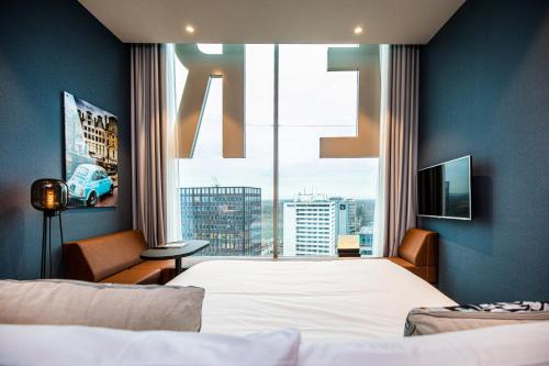 a bedroom with a bed and a large window at Van der Valk Hotel Amsterdam Zuidas -Rai in Amsterdam