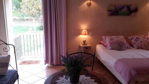 a bedroom with a bed and a table with a plant at Chambres d'hôtes Le Vignoble in Cucuron
