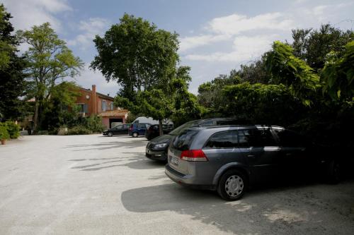 a row of cars parked in a parking lot at Logis Hotel la Ferme in Avignon