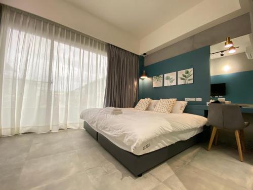a bedroom with a bed and a desk with a computer at Ren House大仁哥文旅 in Taitung City
