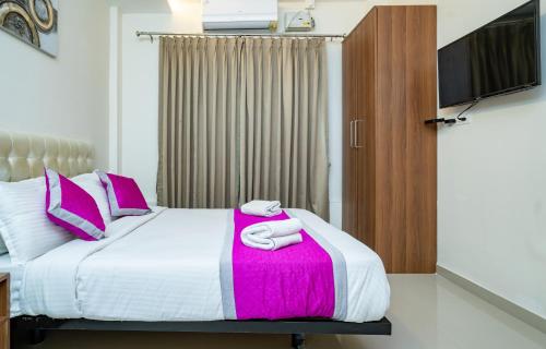 a bedroom with a bed with two towels on it at Nexstay Treats Inn in Kozhikode