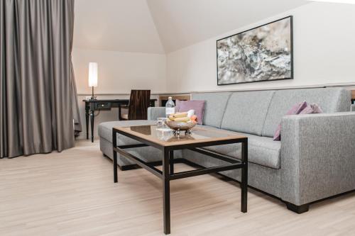 a living room with a couch and a table at Avita Resort Bad Tatzmannsdorf in Bad Tatzmannsdorf