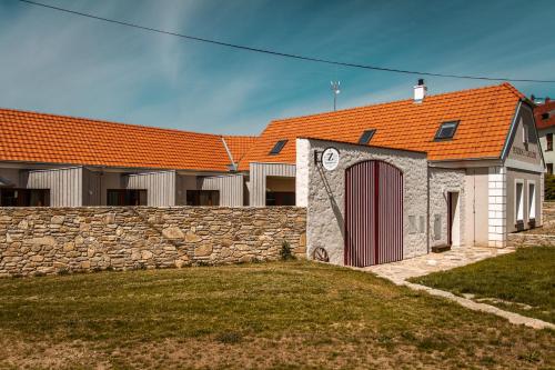 uma casa com um telhado laranja e uma parede de pedra em Penzion U Kapličky em Znojmo