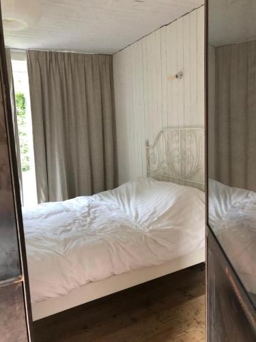 a mirror reflection of a bed in a bedroom at Vakantiehuis De Sneppelhoeve 