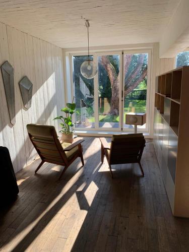 a room with a table and two chairs and a window at Vakantiehuis De Sneppelhoeve in Loenhout