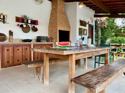 una cocina con una gran mesa de madera y bancos en Pousada Nossa Terra en Rio Novo