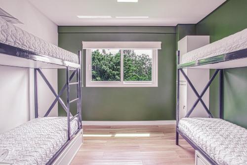 two bunk beds in a room with a window at Pousada Native in Florianópolis