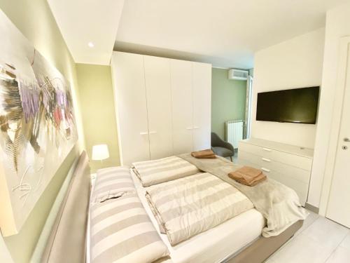 a bedroom with a bed and a flat screen tv at Tower 44 in Luino