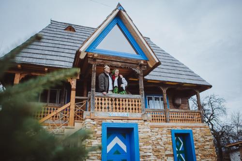dos personas de pie en el balcón de una casa en Casa Moroșenilor - Breb, en Breb