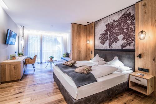 a bedroom with a large bed with a dog laying on it at Sporthotel Zoll in Vipiteno