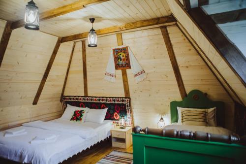 une chambre avec deux lits dans un grenier dans l'établissement Casa Moroșenilor - Breb, à Breb
